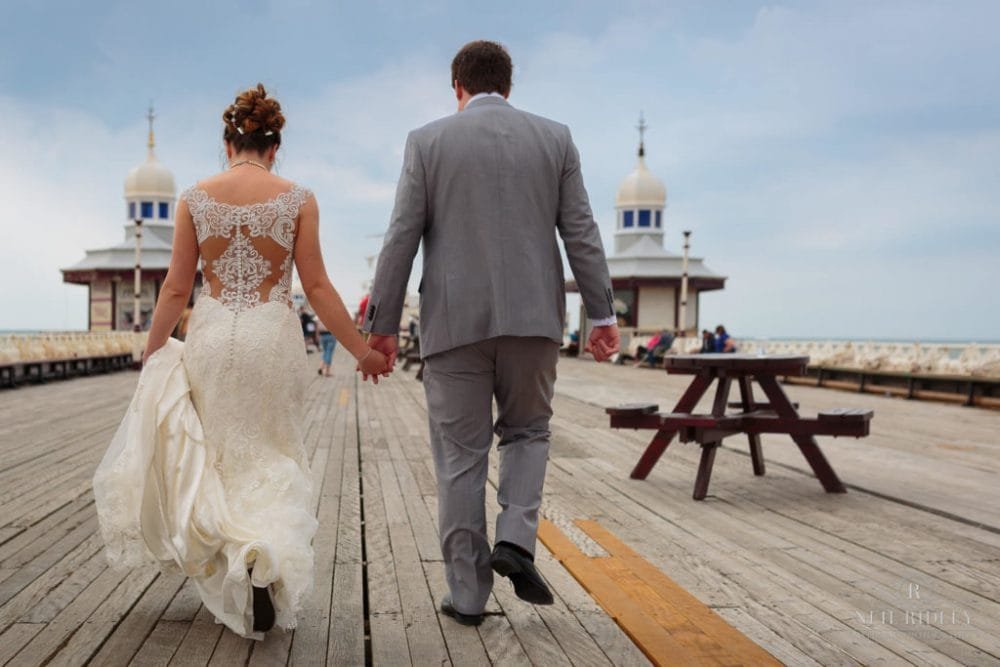 Bride and Groom walk hand in hand on North Pier in Blackpool