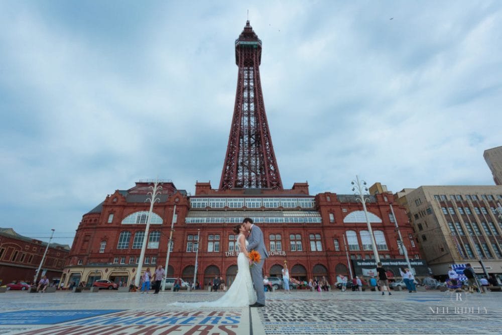 Bride and Groom stand on the Comedy Carpet in front of Blackpool Tower
