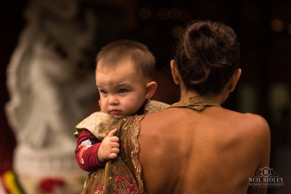 Merrydale Manor Wedding Photographer - Baby looks over mothers shoulder