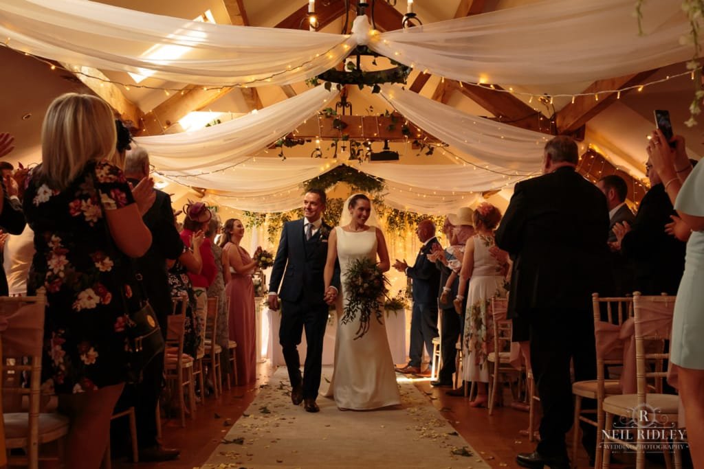 Beeston Manor Wedding Photographer - Bride and Groom walk down the aisle