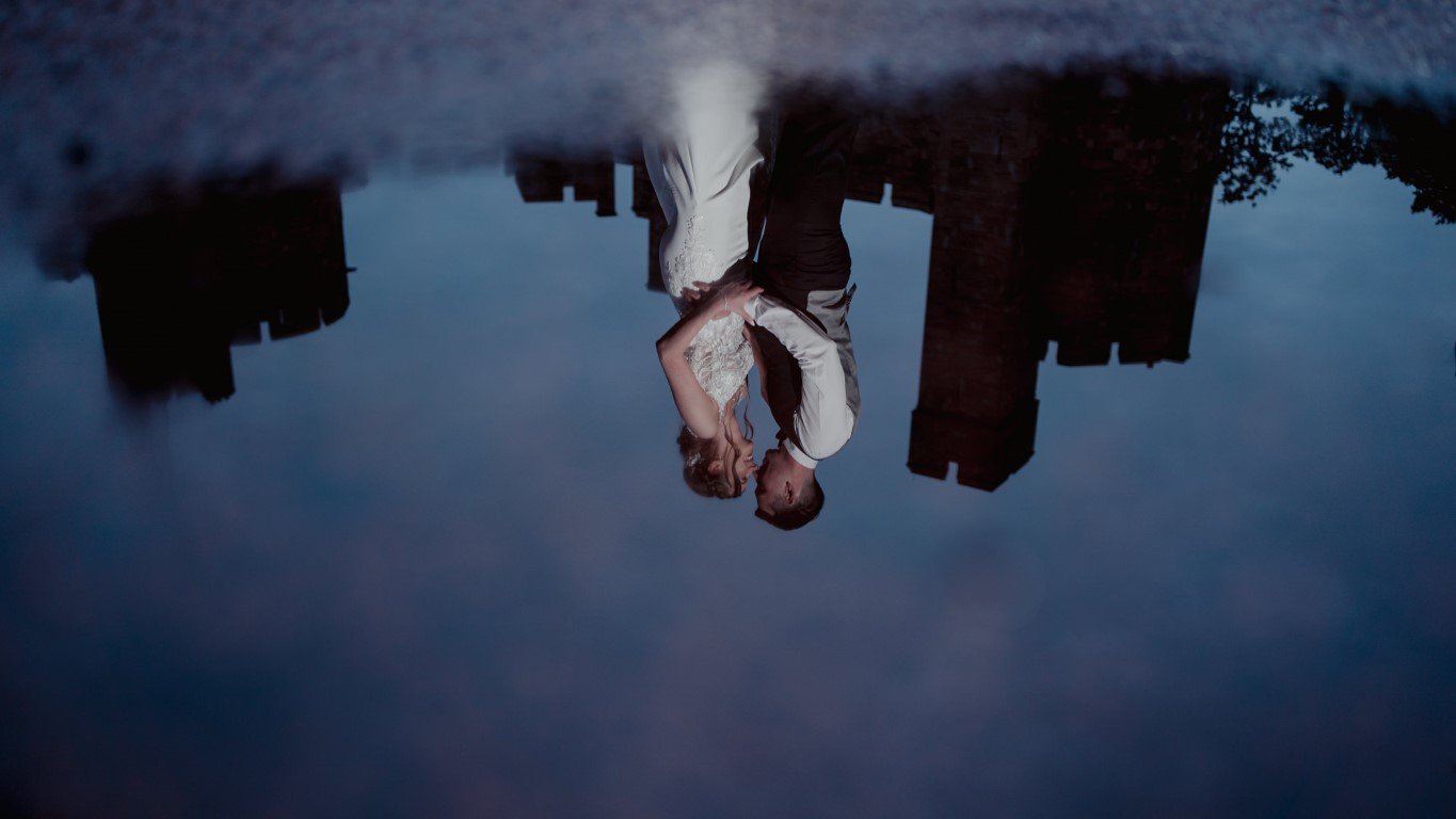 NRB00809 Peckforton Castle Wedding Bride and Groom reflected in a puddle